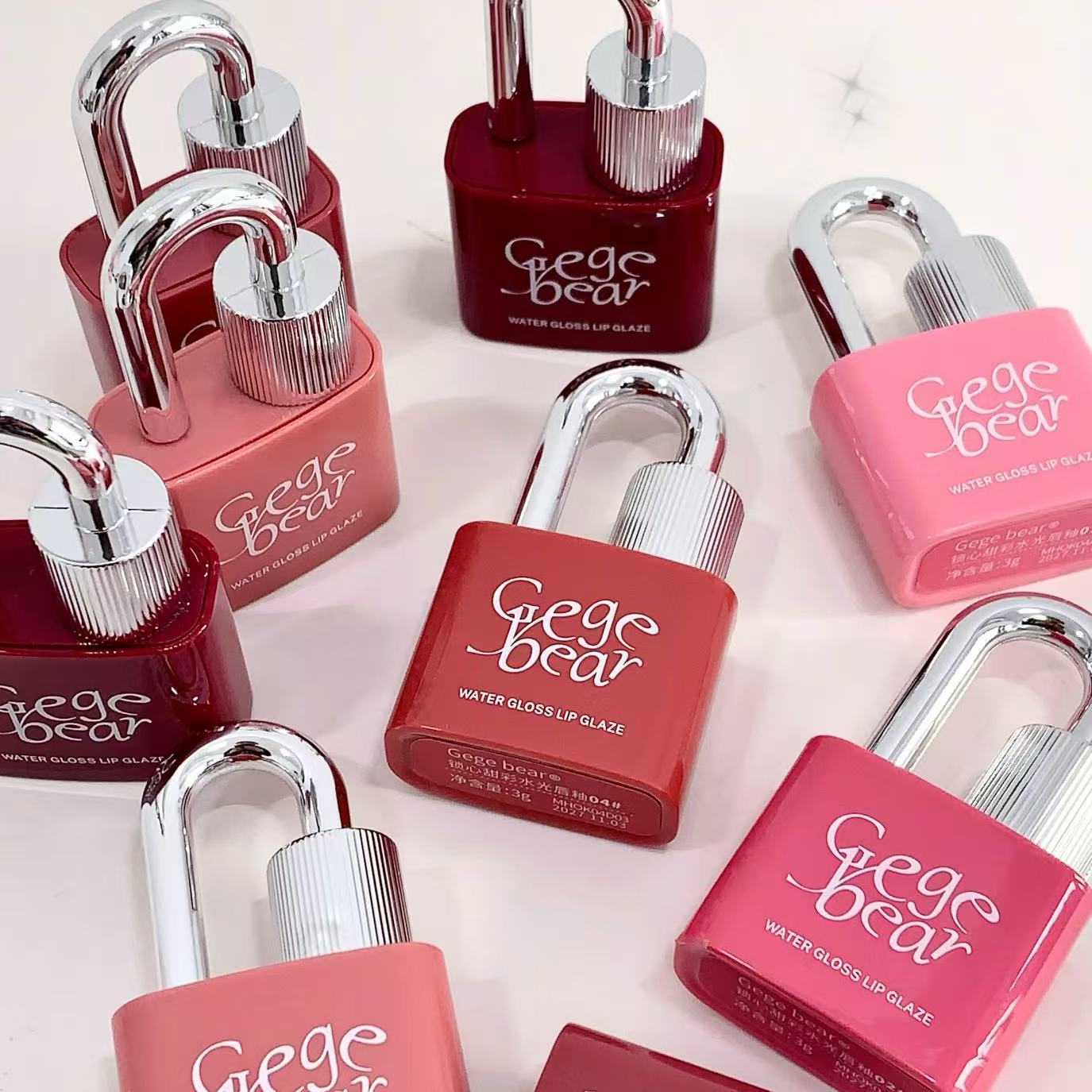 Collection of 'Gige bear' lip glosses in various shades on a light background