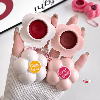 Flower-shaped lip balm cases with 'Gege bear' branding held by a hand.