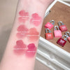 Lipstick swatches on a wrist with labeled colors, next to small pink lock-shaped items.